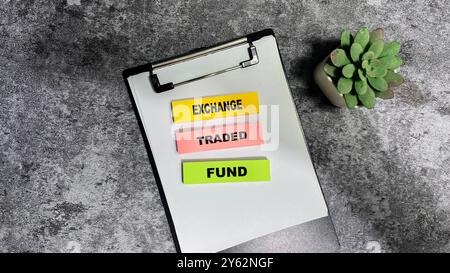 Das Konzept des Exchange Traded Fund schreibt auf Haftnotizen, die auf Holztisch isoliert sind. Stockfoto