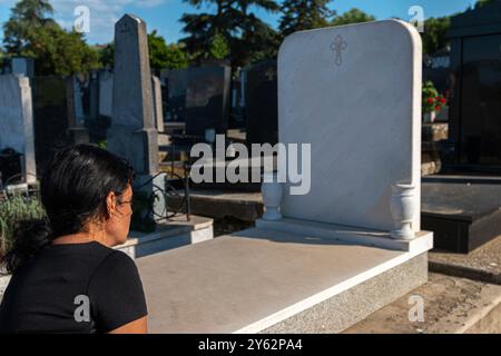 Reife Frau in schwarzer Kleidung auf dem Friedhof und Trauer um Familienverlust. Konzept für Tod, Trauer, Beerdigung und Spiritualität. Stockfoto