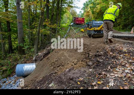 Ein Auftragnehmer des U.S. Army Corps of Engineers verwendet eine Mehrzweck-Tandemwalze während einer Dükerinstallation für Straßenreparaturen entlang des Longhouse National Scenic Drive im Allegheny National Forest in Kane, Pennsylvania, 18. September 2024. Das Projekt zur Straßensanierung ist eine der ersten Partnerschaftsmöglichkeiten für das U.S. Army Corps of Engineers Pittsburgh District, um Dienstleistungen für den Allegheny National Forest zu erbringen. Das Projekt umfasst die Sanierung einer ca. 22 km langen malerischen Straße in der Nähe des Kinzua Dam und des Allegheny Reservoir. Die Finanzierung des Projekts kam vom Great American Outd Stockfoto