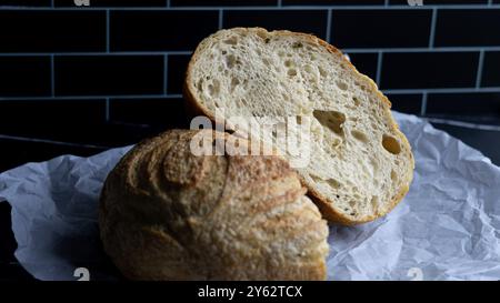 Ein rustikales, hausgemachtes Sauerteigkräuterbrot. Ideal für Food-Blogs, Kochbücher, Websites und Restaurantmarketing Stockfoto