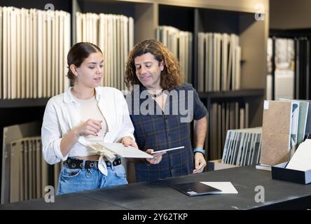 Ehemann und Ehefrau wählen Keramikfliesen für die Küchenverkleidung im neuen Haus Stockfoto