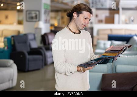 Ein Mann mittleren Alters wählt die Polsterfarbe der Möbel Stockfoto