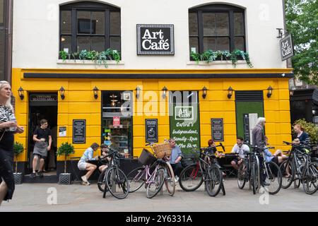 Oxford Großbritannien - 25. Juli 2024; Straßenszene vor dem Art Cafe in Oxford mit Schwerpunkt auf dem Kellner, der aus der Tür kommt. Stockfoto