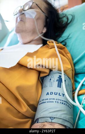 Kranke asiatische alte Patientinnen, die im Krankenhaus den Blutdruck messen Stockfoto