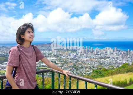 Teen Girl steht an einem hohen Aussichtspunkt mit Blick über die Stadt Honolulu und den Diamond Head Crater und den Pazifik Stockfoto