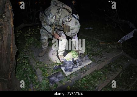 Nicht exklusiv: CHARKIW, UKRAINE - 21. SEPTEMBER 2024 - ein Sprengstoffexperte untersucht das Wrack einer russischen Luftbombe, die in der explodierte Stockfoto