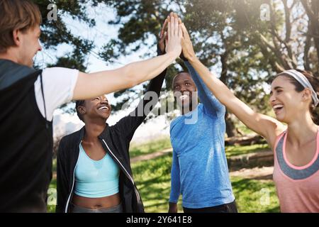 Fitness, ein paar Freunde und High Five im Park für sportliche Aktivitäten mit Einheit, Feier und Solidarität. Menschen, draußen und glücklich oder lächeln mit lauter Gemütlichkeit Stockfoto