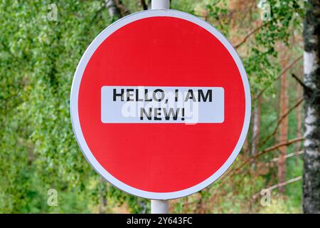 HALLO, ich BIN NEUER Text geschrieben Verkehr ist verboten auf dem Schild vor dem Hintergrund des Waldes Stockfoto