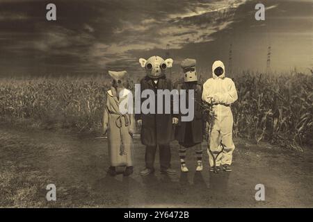 Vier Figuren stehen auf einem Feld unter einem bedrohlichen Himmel, in seltsamen, gruseligen Kostümen und Masken gekleidet. Halloween-Retro-Vibes. Stockfoto