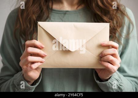 Das Mädchen hält den Umschlag vor sich. Hochwertige Fotos Stockfoto