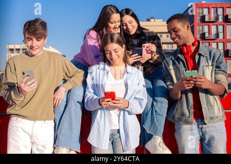Schüler, die Spaß mit Mobiltelefonen haben, um Inhalte in sozialen Medien zu erstellen. Stockfoto