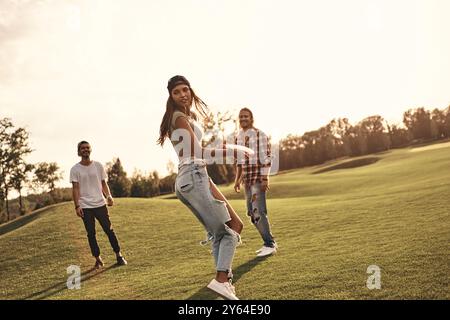 Bereit zum Werfen. In voller Länge junge lächelnde Menschen in Freizeitkleidung, die draußen Frisbee spielen Stockfoto