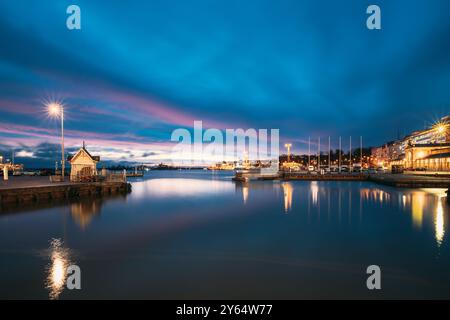 Helsinki, Finnland. Landschaft Mit City Pier, Anlegestelle Bei Winter Sonnenaufgang Sonnenuntergang Zeit. Blauer Himmel Spiegelt Sich In Der Ruhigen Meeresoberfläche Wider. Liegeplatz In Beleuchtung Stockfoto