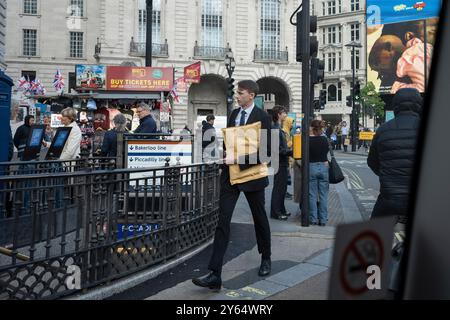 Ein passender junger Mann trägt einen gepolsterten Briefumschlag am 12. September 2024 am Eingang der U-Bahn-Station Piccadilly Circus in London, England. Stockfoto