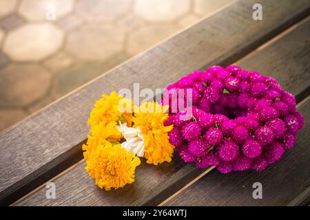 Girlanden Blumen bestehen aus Ringelblume und Globus Amaranth oder Junggesellen-Knopf auf Holzhintergrund. Stockfoto
