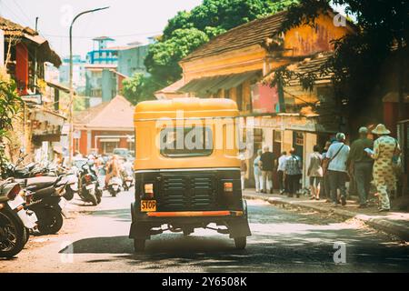 Panaji, Goa, Indien. Gelbe Auto-Rickshaw oder Tuk-Tuk, die am sonnigen Tag auf der Straße unterwegs sind Stockfoto