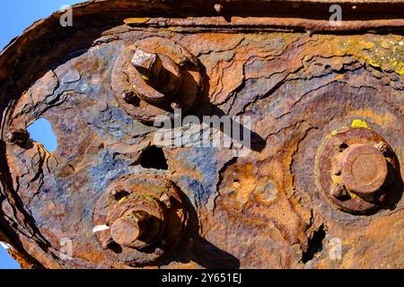 Verrostete Eisenplatte mit verrosteten Schrauben gegen einen blauen Himmel. Foto eignet sich als Hintergrund. Stockfoto