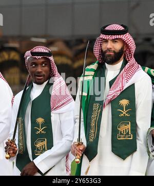 Dschidda, Saudi-Arabien. September 2024. Der französische Fußballspieler Karim Benzema (rechts) tanzt den „Schwerttanz“, auch bekannt als „Ardha“, in traditioneller Saudi-arabischer Kleidung: Ein Gghutra oder Keffieh auf dem Kopf, eine weiße Dschdasha oder Thobe, während er am 22. September 2024 mit seinem Verein „Al-Ittihad“ den Saudi-arabischen Nationalfeiertag (23. September) in Dschidda, Königreich Saudi-Arabien, feiert. Foto: Balkis Press/ABACAPRESS. COM Credit: Abaca Press/Alamy Live News Stockfoto