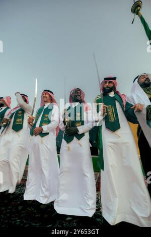 Dschidda, Saudi-Arabien. September 2024. Der französische Fußballspieler Karim Benzema (rechts) tanzt den „Schwerttanz“, auch bekannt als „Ardha“, in traditioneller Saudi-arabischer Kleidung: Ein Gghutra oder Keffieh auf dem Kopf, eine weiße Dschdasha oder Thobe, während er am 22. September 2024 mit seinem Verein „Al-Ittihad“ den Saudi-arabischen Nationalfeiertag (23. September) in Dschidda, Königreich Saudi-Arabien, feiert. Foto: Balkis Press/ABACAPRESS. COM Credit: Abaca Press/Alamy Live News Stockfoto