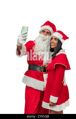 Der vertikale Weihnachtsmann und seine Frau machen gerne ein Selfie zusammen mit ihrem Smartphone und halten einen freudigen Moment während der Weihnachtszeit fest Stockfoto