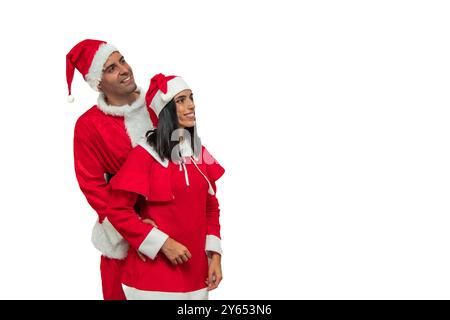 Fröhliches Paar in lebendigen Santa Claus Outfits umarmt warm und strahlt Freude und Glück aus. Mit einem großen Lächeln im Gesicht schauen sie zu Stockfoto