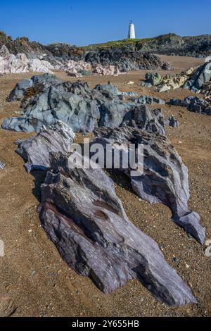 Llanddwyn Island. Leuchtturm Tŵr Mawr, das Original hinter den Felsen am Strand. Stockfoto
