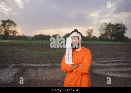 Indischer Bauer, jung, stehend auf einem Ackerfeld Stockfoto