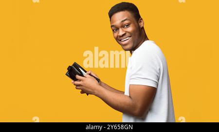 Portrait von schwarzen Kerl holding Geldbörse mit Geld Stockfoto