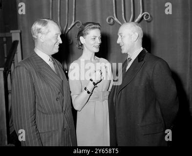 Das unterhaltsame Trio im Empire Theatre, Leicester Square, nahm an den Proben der Royal Film Performance 1959 Teil. Von links nach rechts sind Maurice Chevalier , die US-amerikanische Schauspielerin Lauren Bacall und der englische Schauspieler Alec Guinness . Guinness spielt die Hauptrolle im königlichen Film The Horse's Mouth , der vor Königin Elizabeth der Königin Mutter gezeigt wird . 1. Februar 1959 Stockfoto