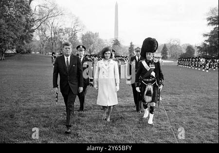 Frau Jacqueline Kennedy , die First Lady of America , spaziert über den South Lawn ihres Hauses im Weißen Haus , dem Tag , an dem das Royal Highland Regiment Black Watch im Rasen in Washington DC , USA auftrat . An ihrer Seite trägt Präsident John F Kennedy einen dirk, den er gerade vom Major WM Wingate Gray (rechts) Commander der Black Watch erhalten hatte. 1700 Kinder aus Kinderbetreuungseinrichtungen schauten auf Einladung des US-Präsidenten Washington DC die Ausstellung an . - 15. November 1963 Stockfoto