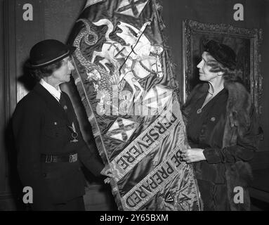 Im Hauptquartier der Girl Guides Association ist der Standard of St George zu sehen , der der ehemaligen Chefkommissarin für England , Frau Percy Birley , von der Prinzessin Royal überreicht wird . danach wird er der jetzigen Chefkommissarin Lady Cochrane übergeben . Der Standard wurde 1937 eingeführt , wurde aber bis 1947 eingestellt und entspricht 6.000 Arbeitsstunden . Das meiste davon wurde von der Hon Miss Rachel Kay Shuttleworth , 32 Jahre lang County Commissioner for Lancashire , N.E. , durchgeführt und gilt als eines der beeindruckendsten Handarbeiten des 20. Jahrhunderts . Blick auf den Stand Stockfoto