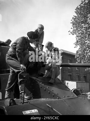 Drei kleine Jungen bekommen den Geschmack des Abenteuers , während sie auf der Stahlschale eines gepanzerten Autos sitzen , während Trooper , BH Morse , die Funktelefonie während des Elterntages der Royal Horse Guard in Combermere Barracks in Windsor erklärt . Die Jungs sind von links nach rechts George Vince , Ian Andrews und Charles Coles . Familien und Freunde der Royal Horse Guards ( The Blues ) wurden eingeladen, dem Regiment bei der Arbeit zuzusehen - sowohl als gepanzerte als auch als Kavallerie-Einheit . 8. Mai 1954 Stockfoto