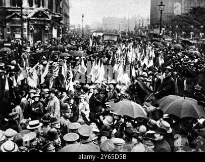 Das Recht der Frau , am 17 . Juli 1915 Tausende von Frauen aus allen Klassen zu demonstrieren , das als Recht organisiert wurde , Frauen zu erlauben , sich an Munition und anderer Kriegsarbeit zu beteiligen , war ein Erfolg in jedem Detail , außer dem Wetter . Die Demonstration war historisch , ehrenvoll und patriotisch , von dieser erstaunlichen Frau , die sich danach sehnt für den Krieg zu arbeiten . Frauen hier mit Fahnen und Spruchbändern im Schatten der Houses of Parliament , London , England gesehen . 24. Juli 1915 Stockfoto