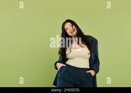 Eine atemberaubende Frau in Übergröße zeigt ihren Stil in einem eleganten Anzug und strahlt vor grünem Hintergrund Selbstvertrauen aus. Stockfoto