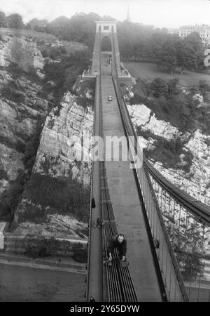 Herr Alfred Heal von St Werburgh , Bristol , ist ein Mann , der aussieht , als hätte er einen Job fürs Leben . Er ist neun Jahre lang Mitglied des Malerteams , dessen Aufgabe es ist , die Clifton Suspension Bridge , die die Avon-Schlucht überspannt , zu behalten , " Ship-Shape and Bristol Fashion " . Vier Tonnen Farbe und 22 kg Teer werden jährlich für die Arbeit benötigt , und wenn die Maler die Aufgabe erledigt haben , ist es an der Zeit zurück zu gehen und wieder von vorne anzufangen . Das Bild zeigt: Mr. Alfred Heal saß auf einer der Ketten, 360 Meter über dem Portway von Bristol und half dabei, die große Brücke zu halten Stockfoto