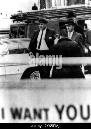 Neshoba County Miss, Sheriff Lawrence Rainey (links) und sein Stellvertreter Cecil Price gehen zum Bundesgebäude für ihre vorläufige Anhörung vor einem US-kommissar. Die beiden gehörten zu einer Gruppe von Männern, die im Zusammenhang mit der Ermordung von drei Bürgerrechtlern angeklagt wurden. Im Vordergrund steht ein Teil des Oncle Sam Recruiting Posters vor dem Postamt . Meridian, Miss 10. Dezember 1964 Stockfoto