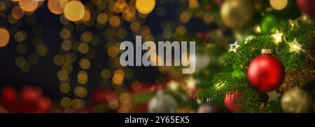 Festliche, glänzende Weihnachtsszene mit der Nahaufnahme einer schön verzierten Tanne und vielen Bokeh-Lichtern auf dunklem Hintergrund, breites Panoramaformat Stockfoto
