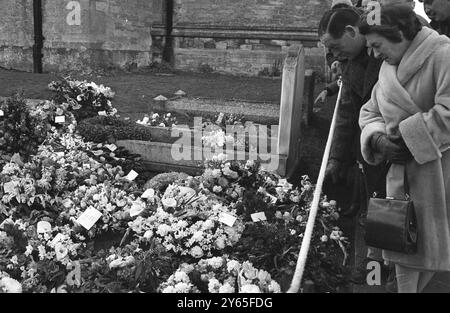 Besucher des Kirchhofs von Bladon Besucher werden am mit Blumen bewachsenen Grab von Sir Winston Churchill nach dem Begräbnis des Staatsmannes auf diesem bescheidenen Kirchhof von St. Martin's gesehen . 31. Januar 1965 Stockfoto