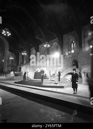 In der von Offizieren der Royal Navy bewachten Halle der Könige liegt der mit Fahnen versehene Sarg des verstorbenen Sir Winston Churchill auf einer schwarz gedeckten Katafalke in der 800 Jahre alten Halle der Könige in Westminster nur wenige Meter vom House of Commons entfernt , wo er seine Nation im Zweiten Weltkrieg zum Sieg führte . Januar 1965 Stockfoto