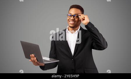 Lächelnd african american Kerl mit Laptop im Studio Stockfoto