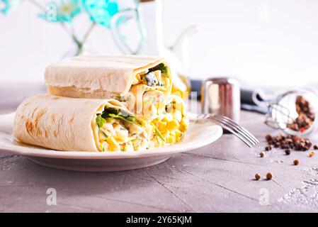 Füllung, Gurke und Mais werden dem entfalteten Pitabrot hinzugefügt. Herstellung von Pita-Brötchen. Stockfoto