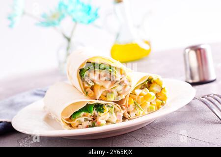 Füllung, Gurke und Mais werden dem entfalteten Pitabrot hinzugefügt. Herstellung von Pita-Brötchen. Stockfoto