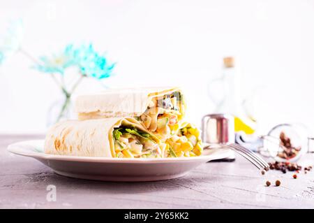 Füllung, Gurke und Mais werden dem entfalteten Pitabrot hinzugefügt. Herstellung von Pita-Brötchen. Stockfoto