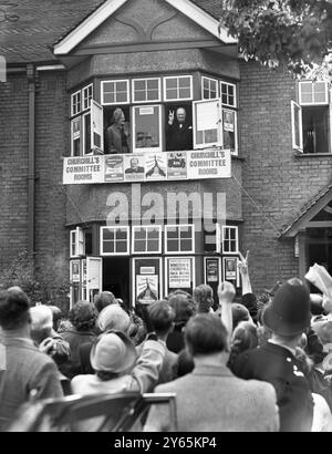 Churchill Macht Wahlkampf. Wenn sie aus einem Fenster blickt , lacht Frau Churchill, während ihr Ehemann Winston Churchill sein bekanntes Siegeszeichen aus dem anderen überreicht , um ihn unten zu begrüßen . Oktober 1951 Stockfoto