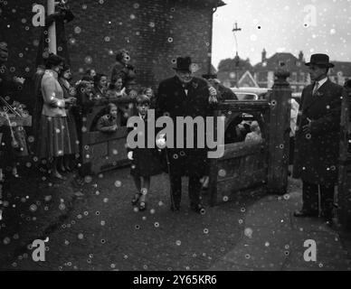 Premierminister Sir Winston Churchill mit Enkel Nicholas Soames , der zur Taufe seiner jüngsten Enkelin Charlotte Clementine Soames in der Westerham Parish Church eintraf . Das Baby ist die Tochter von Captain Christopher Soames und der ehemaligen Mary Churchill , die drei weitere Kinder haben . 6. November 1954 Stockfoto