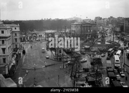 Der Londoner Verkehr verfährt die Straße um die Hyde Park Corner. Der Hyde Park Corner Screen und das Apsley House sind auf der Rückseite zu sehen. Kräne und Bauarbeiten sind zu sehen, wenn mit dem Bau der neuen Unterführung begonnen wurde . Es war ein Abschnitt der weiter gefassten Marble Arch - Park Lane - Hyde Park Corner Road, die weiter ausgebaut wurde. Dies war Teil eines Plans zur Verringerung der Verkehrsstaus auf den Straßen im Zentrum Londons . Es wurde 1962 am 6. Februar 1961 eröffnet Stockfoto