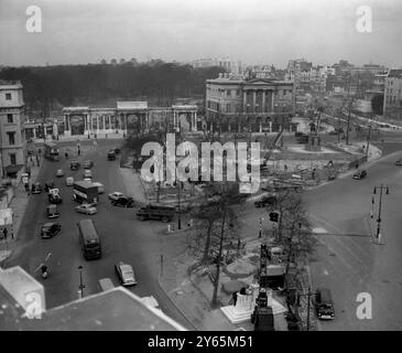 Der Londoner Verkehr verfährt die Straße um die Hyde Park Corner. Der Hyde Park Corner Screen und das Apsley House sind auf der Rückseite zu sehen. Kräne und Bauarbeiten sind zu sehen, wenn mit dem Bau der neuen Unterführung begonnen wurde . Es war ein Abschnitt der weiter gefassten Marble Arch - Park Lane - Hyde Park Corner Road, die weiter ausgebaut wurde. Dies war Teil eines Plans zur Verringerung der Verkehrsstaus auf den Straßen im Zentrum Londons . Es wurde 1962 am 6. Februar 1961 eröffnet Stockfoto