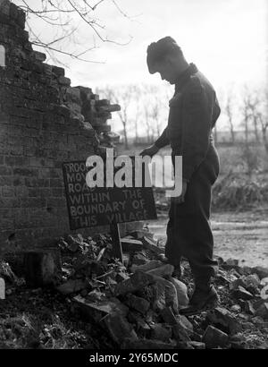 Die Dorfbewohner von Imber warten seit 1943 auf die Erlaubnis, in ihre Häuser zurückzukehren, aber sie wissen jetzt, dass ihr schönes Domesday Village für immer verlassen bleiben wird, mitten in einer Armee-Kampfschule. Das Foto zeigt einen Hinweis, der Soldaten vor den Grenzgebieten in Imber warnt, wird von einem Soldaten neben einer zerbröckelten Mauer im verlassenen Dorf gelesen. April 1948 Stockfoto