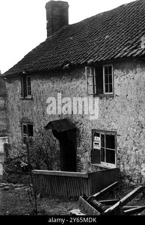 Das Postamt des Dorfes in Imber. Fensterlos und mit der kaputten Winde aus einem gut davor liegenden Garten. Die Dorfbewohner von Imber warten seit 1943 auf die Erlaubnis, in ihre Häuser zurückzukehren, aber sie wissen jetzt, dass ihr schönes Domesday Village für immer verlassen bleiben wird, mitten in einer Armee-Kampfschule. April 1948 Stockfoto