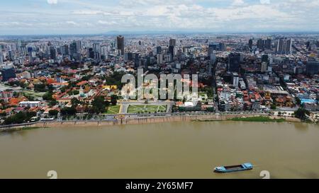 Phnom Penh, Kambodscha - 18. Juni 2022: Aus der Vogelperspektive auf den Tonle SAP Mekong, der vom Königspalast-Komplex links und dem Himmel der Hauptstadt Kambodschas umgeben ist Stockfoto